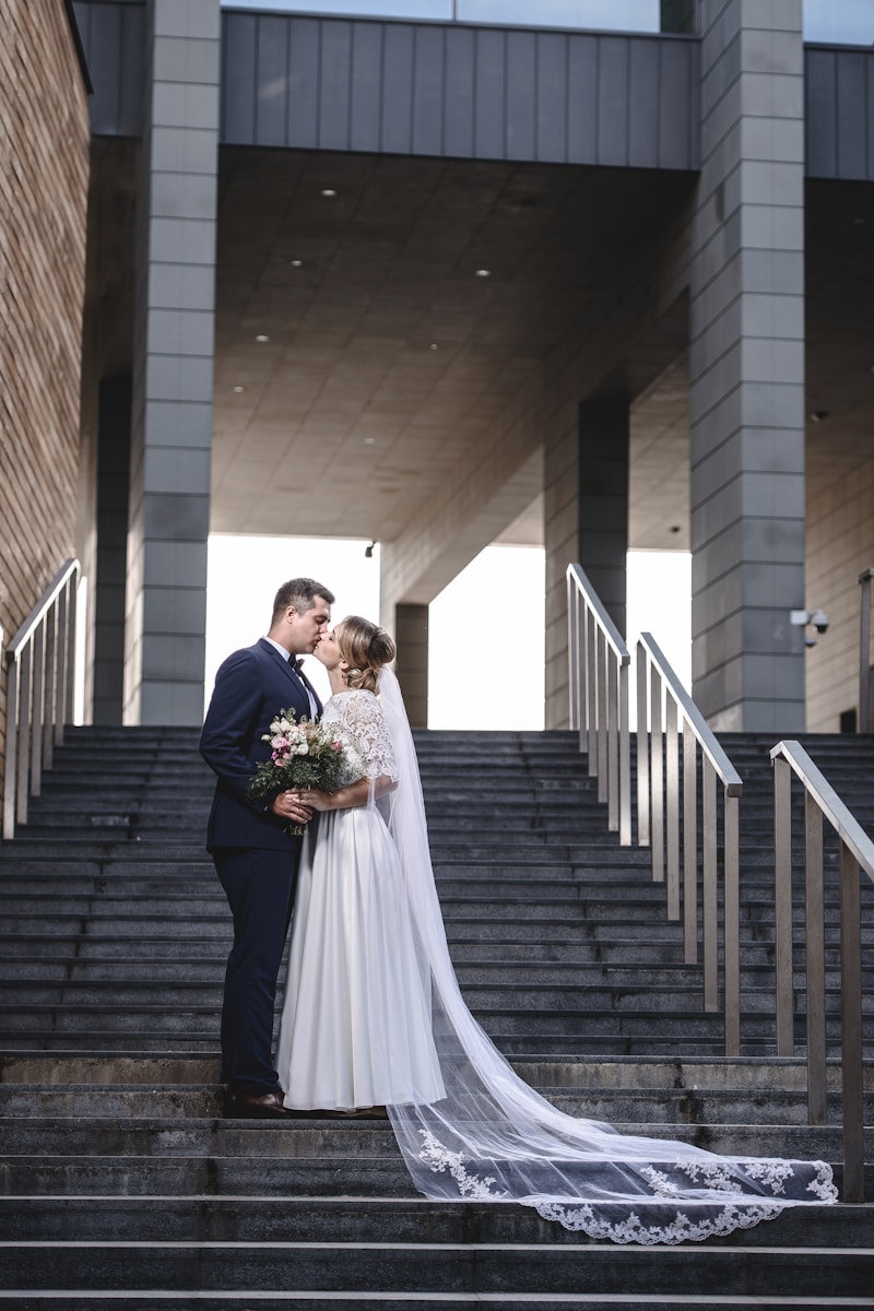 a bride and groom standing on the steps of a building